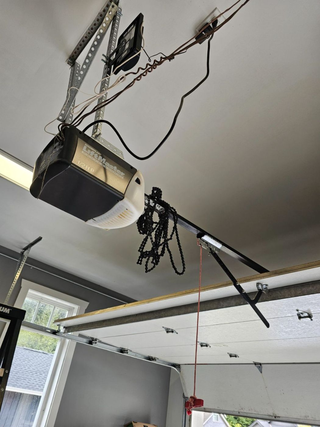 LiftMaster Professional 1/2 HP chain-drive opener at a Coquitlam home with the drive chain hanging loose in tangled loops below the rail