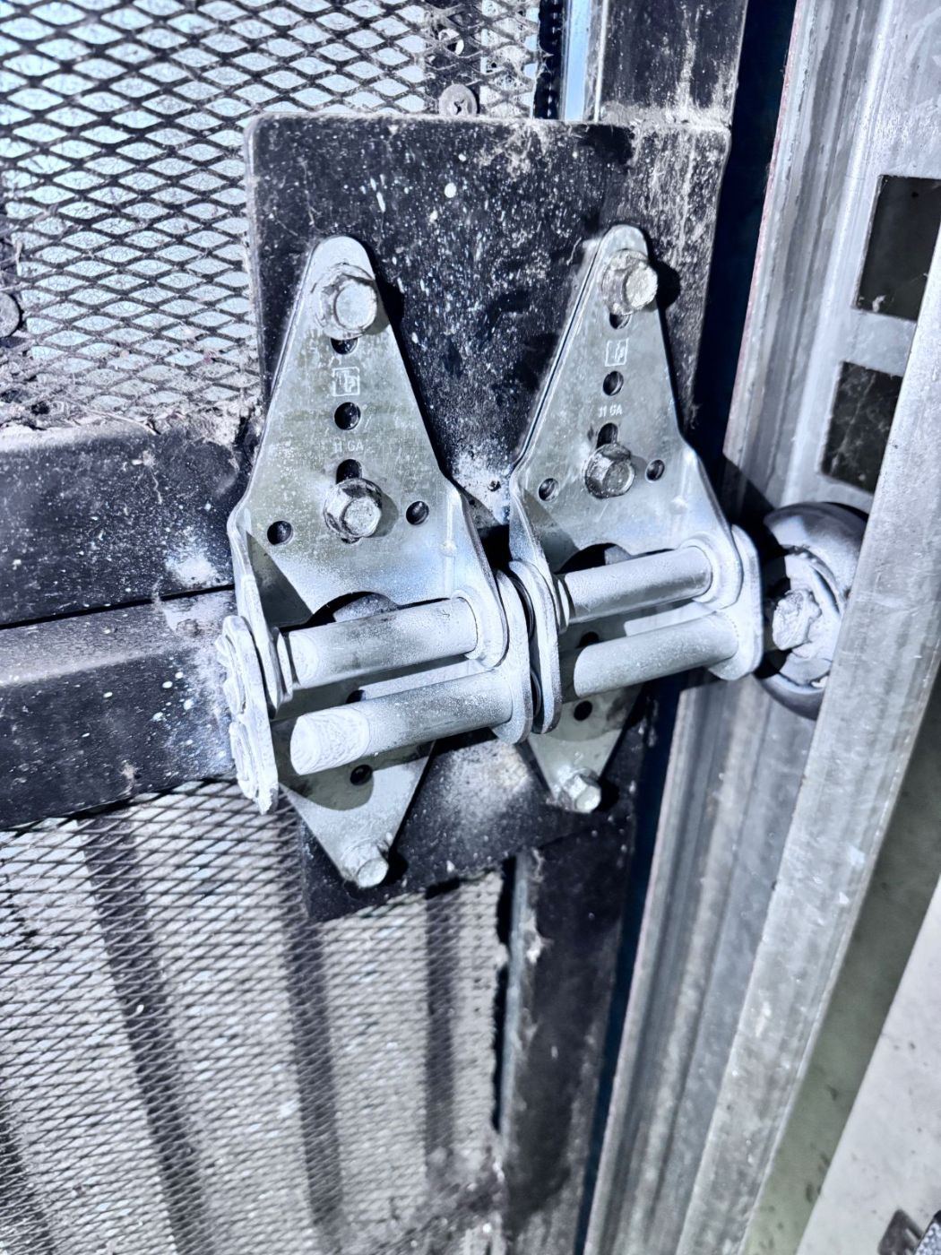 Two frayed garage door lifting cables side by side — left cable showing fiber pull-out from corrosion, right cable still intact — caught during a POCO scheduled maintenance inspection in Coquitlam