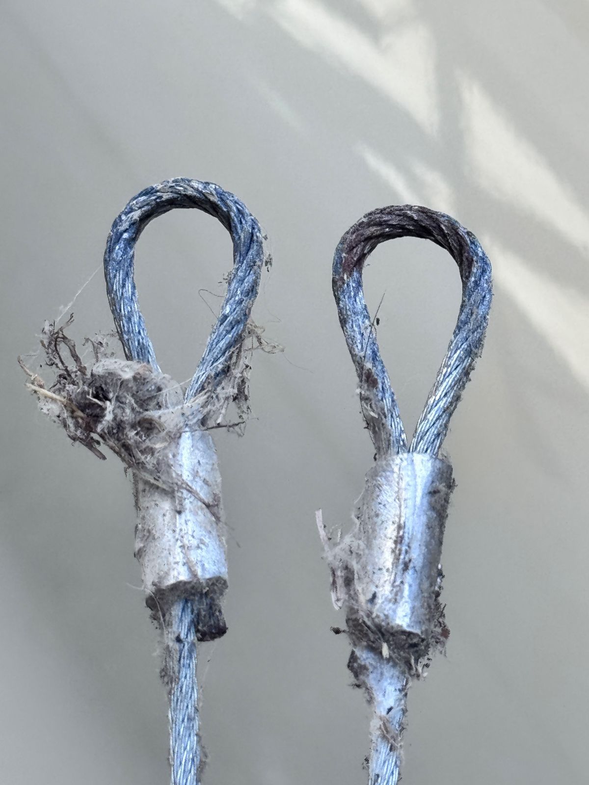Worn 11-gauge garage door hinges and end bearing plate covered in white grease residue and dust — documented during a POCO maintenance visit in Port Moody