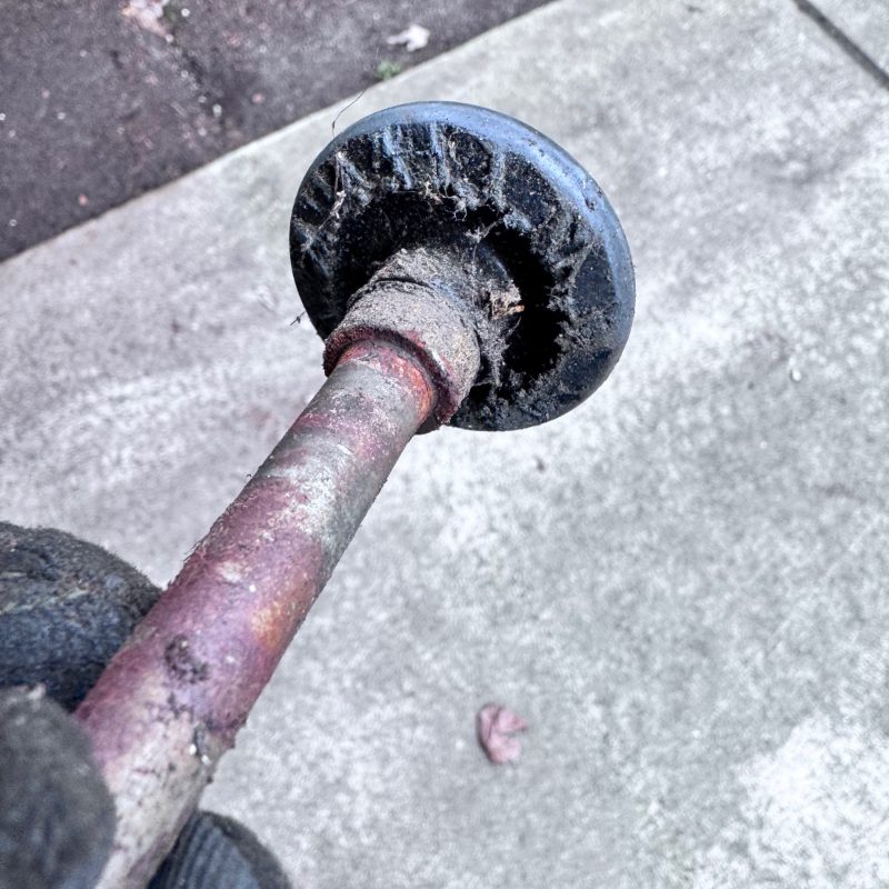 Worn out garage door roller with damaged plastic wheel and bent stem