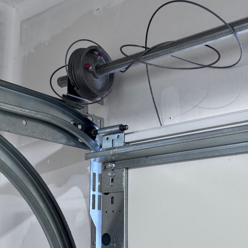 Garage door cable off the drum and tangled around the torsion shaft