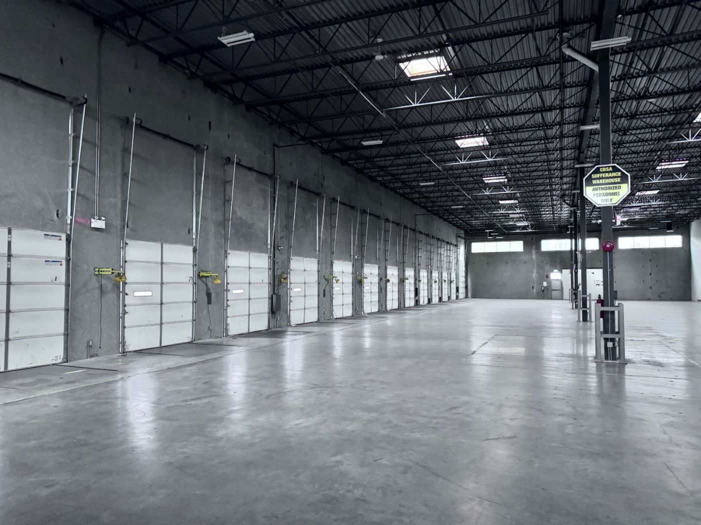 Row of commercial bay doors at a Tri-Cities warehouse serviced by POCO Garage Doors