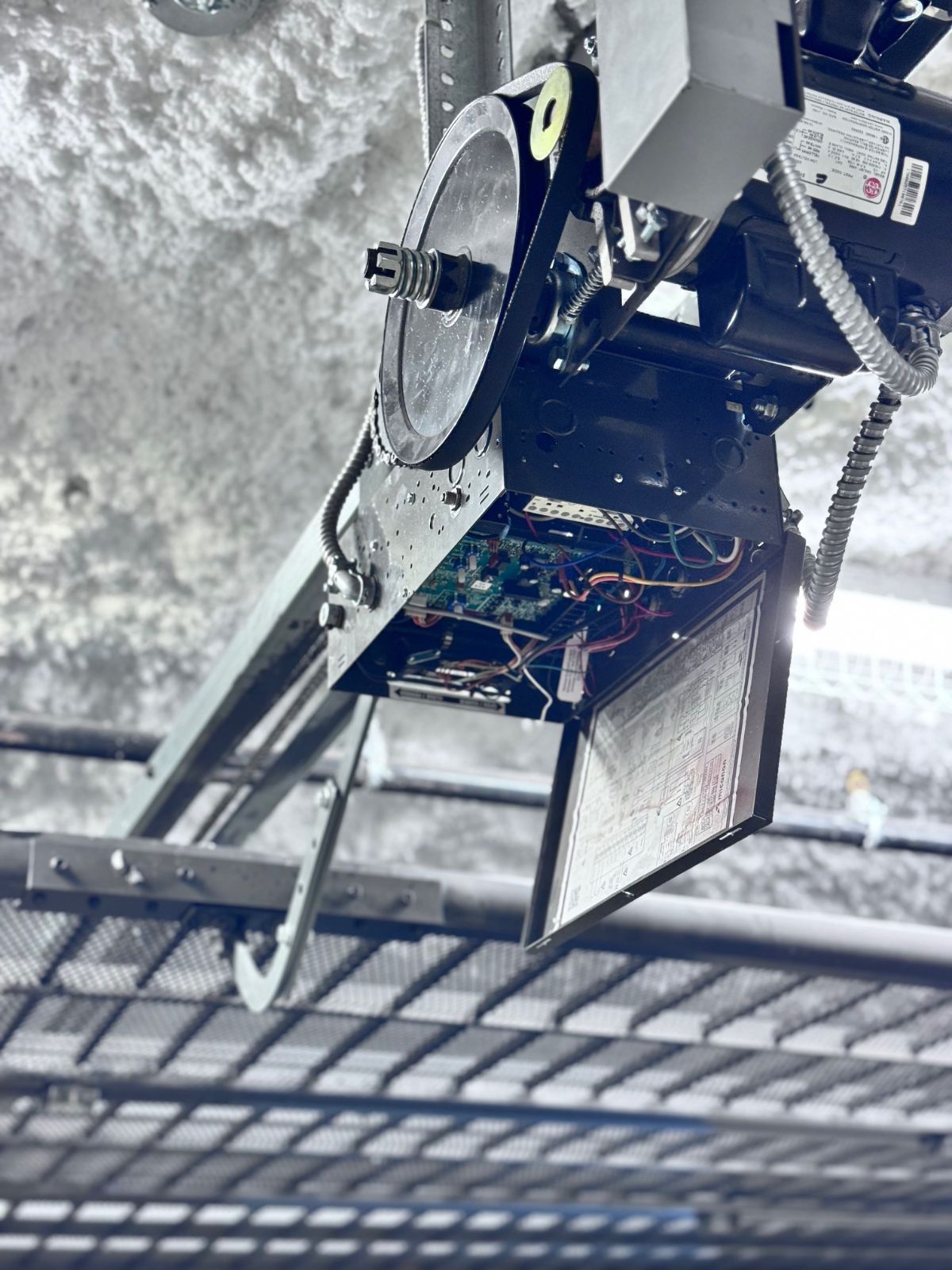 Commercial jackshaft garage door opener with control board exposed during service in Port Coquitlam
