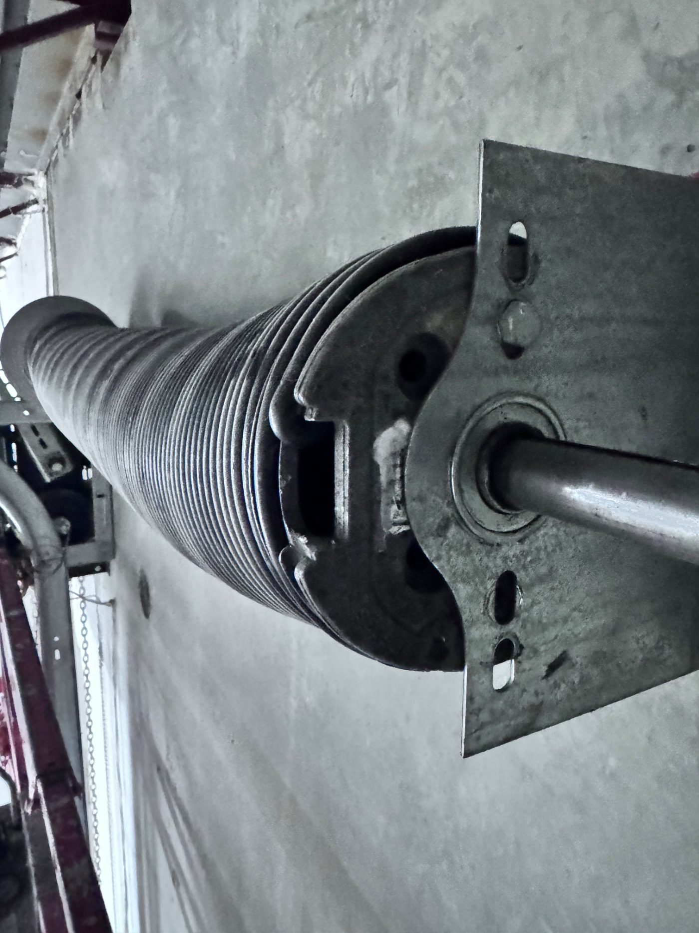 Broken commercial torsion spring on shaft of a Port Coquitlam loading bay door