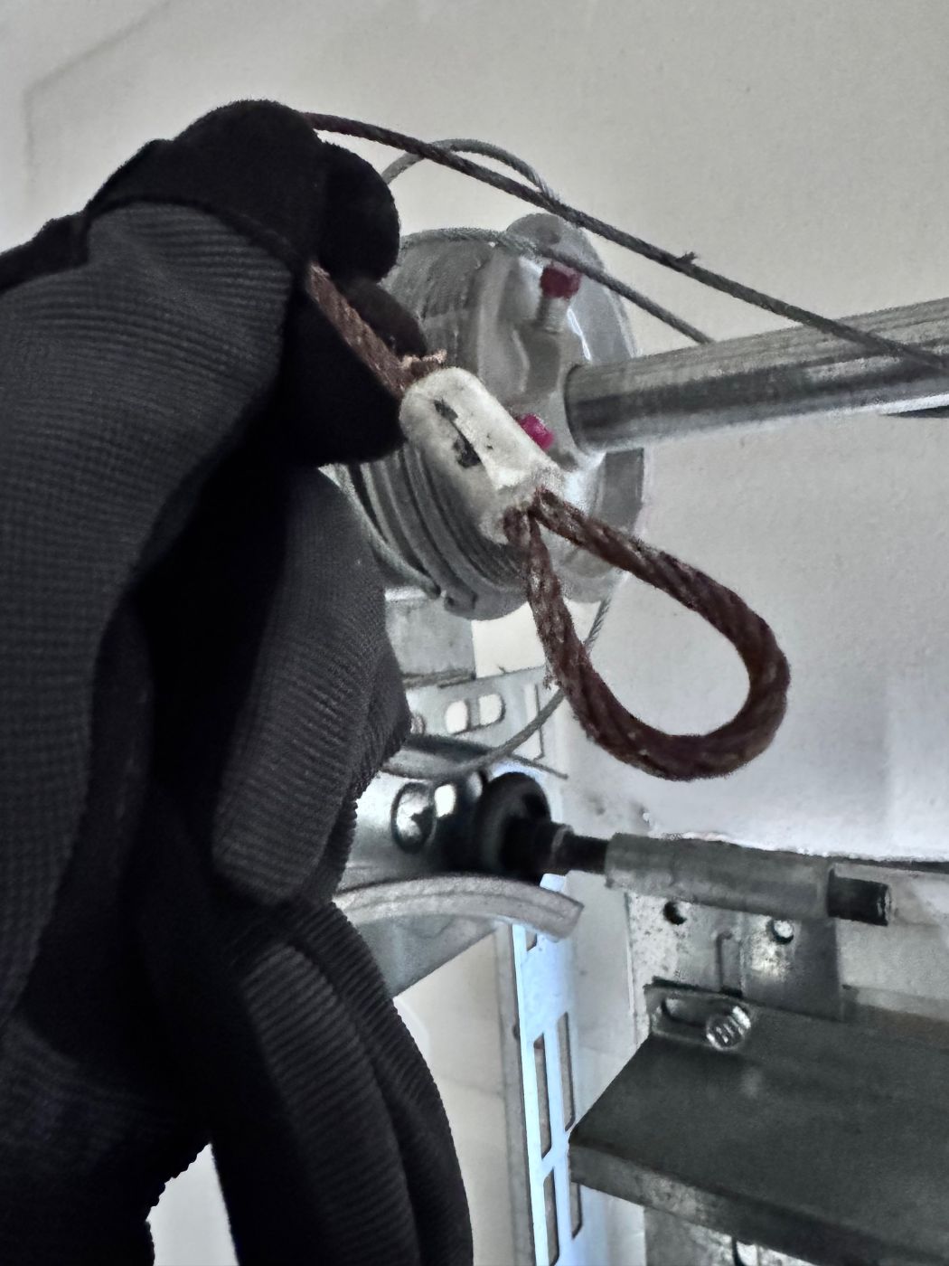 Rusted, frayed garage door cable looped around the cable drum on a Port Coquitlam home — ready for replacement
