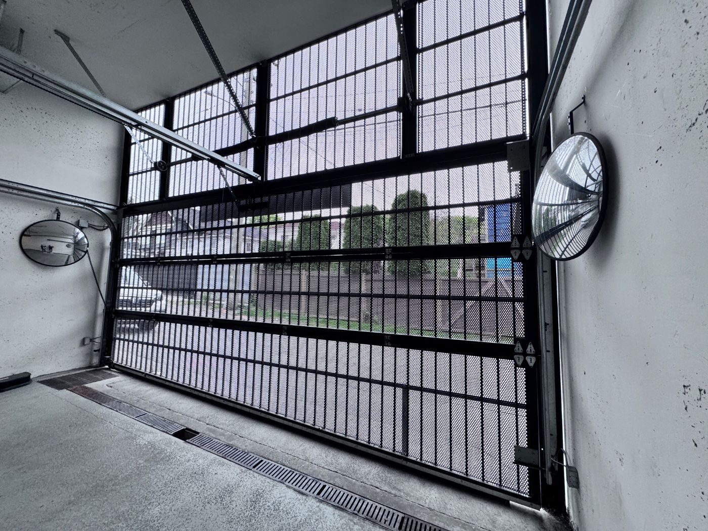 Black mesh parkade security gate at a Port Coquitlam strata building serviced by POCO Garage Doors under a preventive maintenance agreement