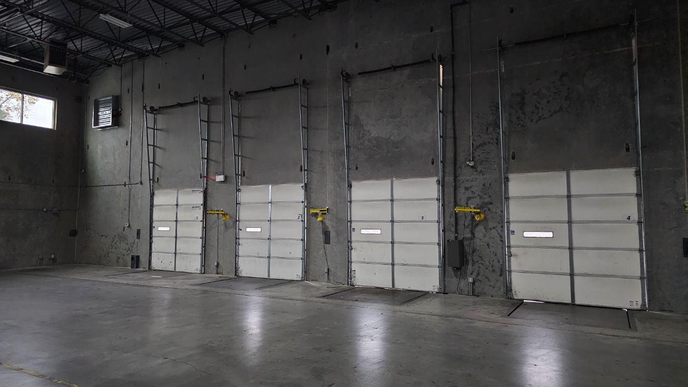 Multi-unit warehouse loading dock with sectional overhead doors serviced by POCO Garage Doors in Coquitlam